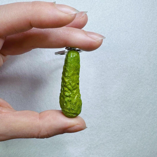 Close-up of realistic gherkin pickle keychain held in hand