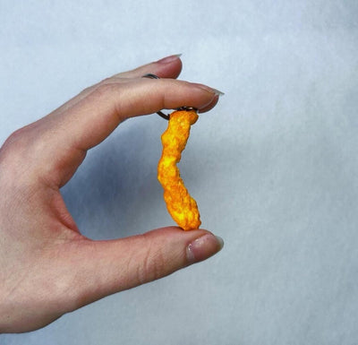 Hand holding a realistic Cheeto keychain